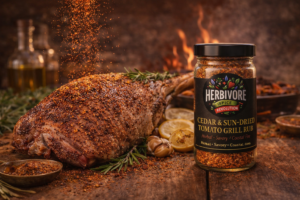 Leg of lamb seasoned with Herbivore Spice Cedar & Sun-Dried Tomato Grill Rub on a rustic wooden table